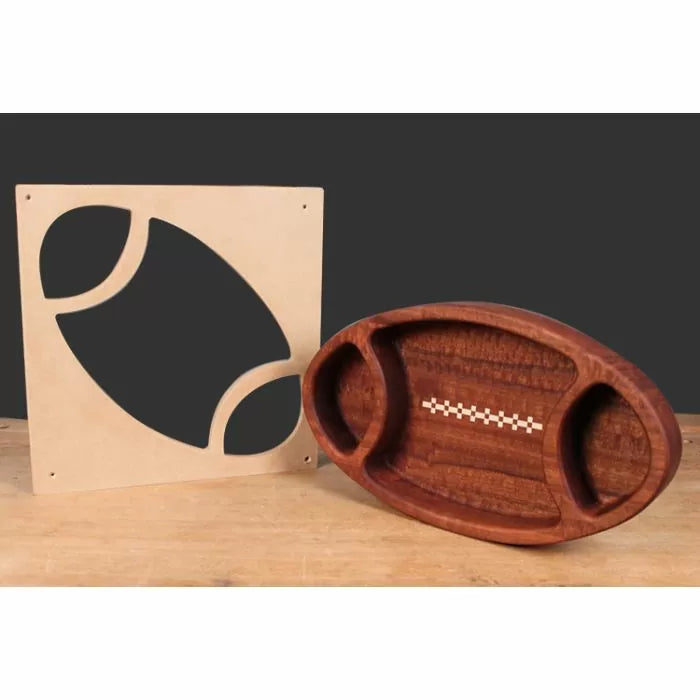 Football-shaped wooden tray with inlays and matching woodworking template on workbench