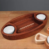 Wooden serving tray with inlay design, featuring two round compartments with white bowls, on a wooden table.