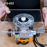 Clear router table baseplate attached to wood router on workbench, woodworking tool setup.