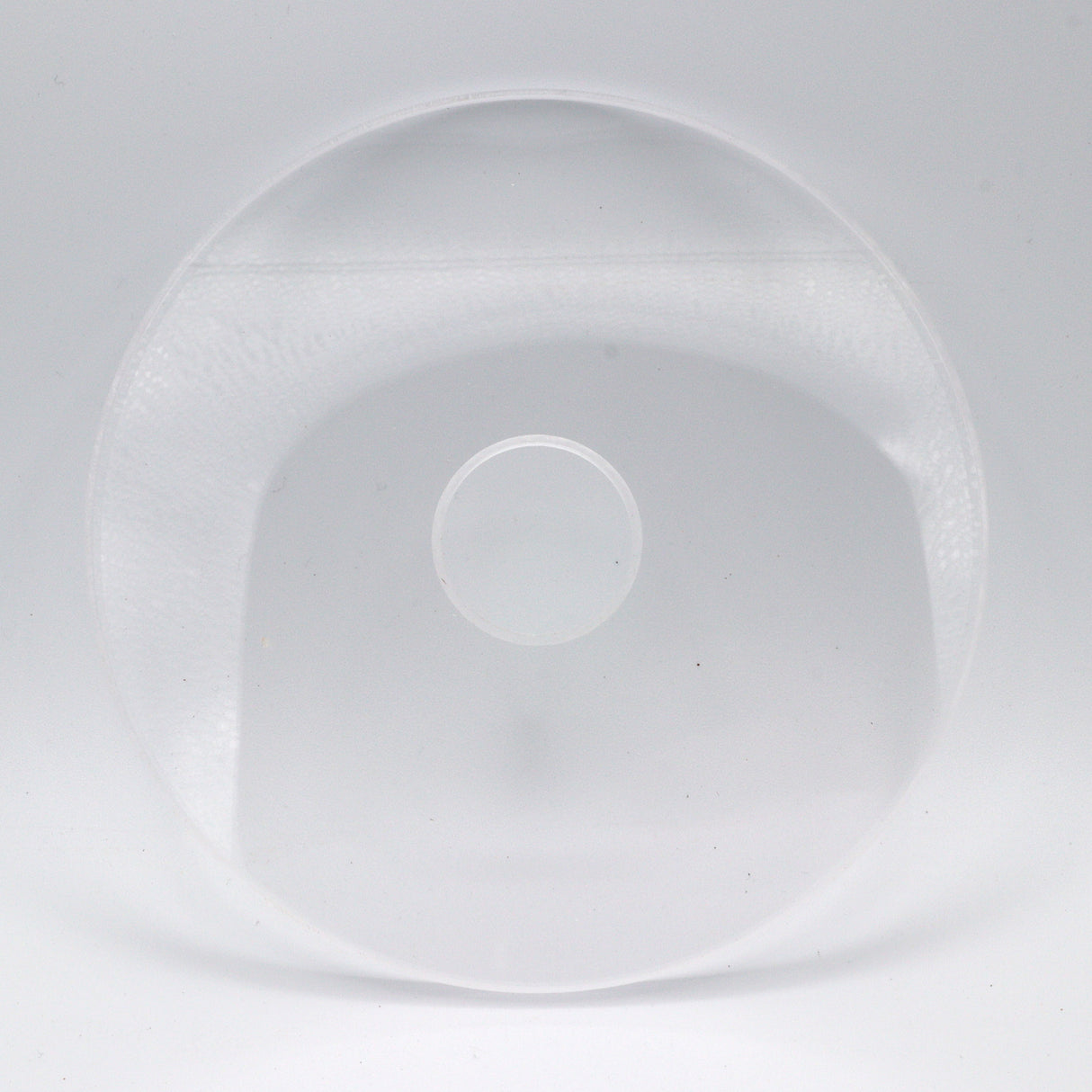 Clear round router table insert plate with center hole on white background