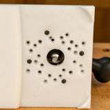 Router table insert plate with multiple mounting holes and a central router bit