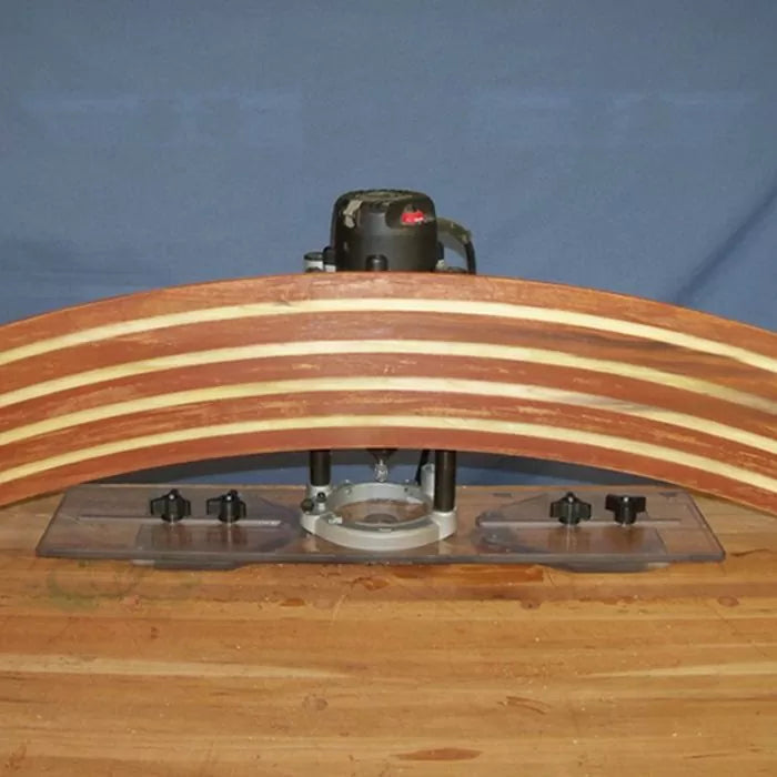 Router table jig setup on workbench with curved laminated wood piece for woodworking