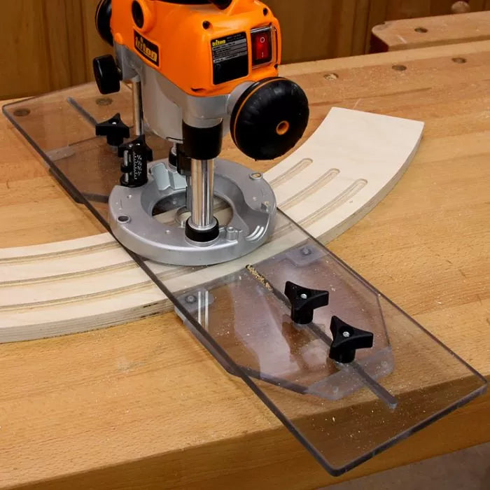 Plunge router with clear guide attached cutting precise curved grooves in wood.