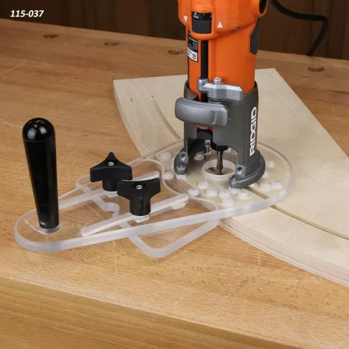 Wood router trimming curved wood with an acrylic edge guide on a workbench