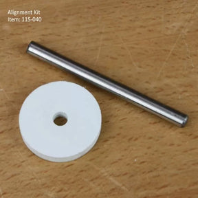 Router table alignment kit with metal rod and white centering disk on wood surface