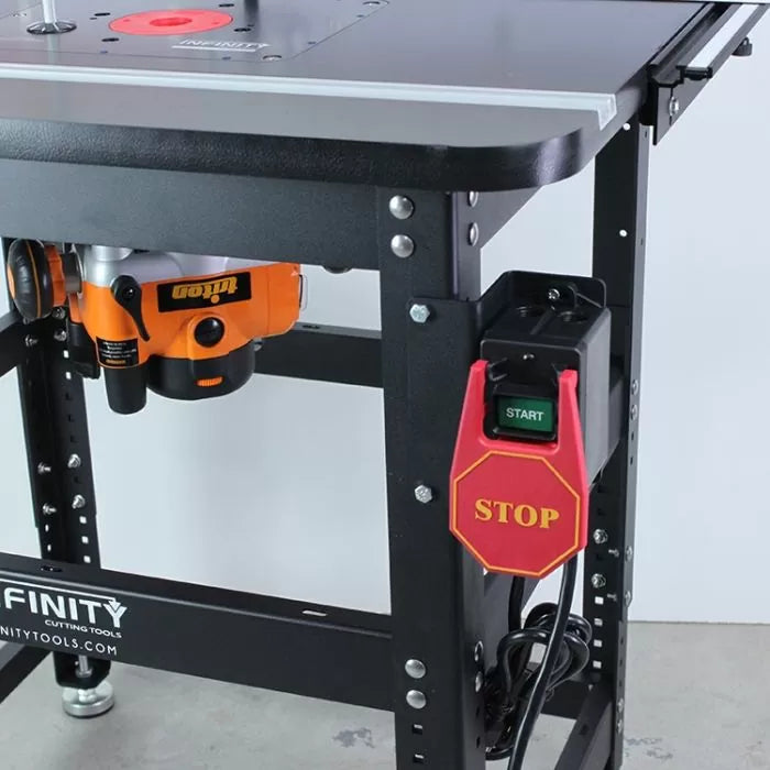 Close-up of a woodworking router table with installed safety power switch and mounted router.