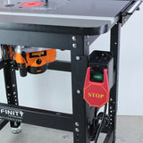 Close-up of a woodworking router table with installed safety power switch and mounted router.