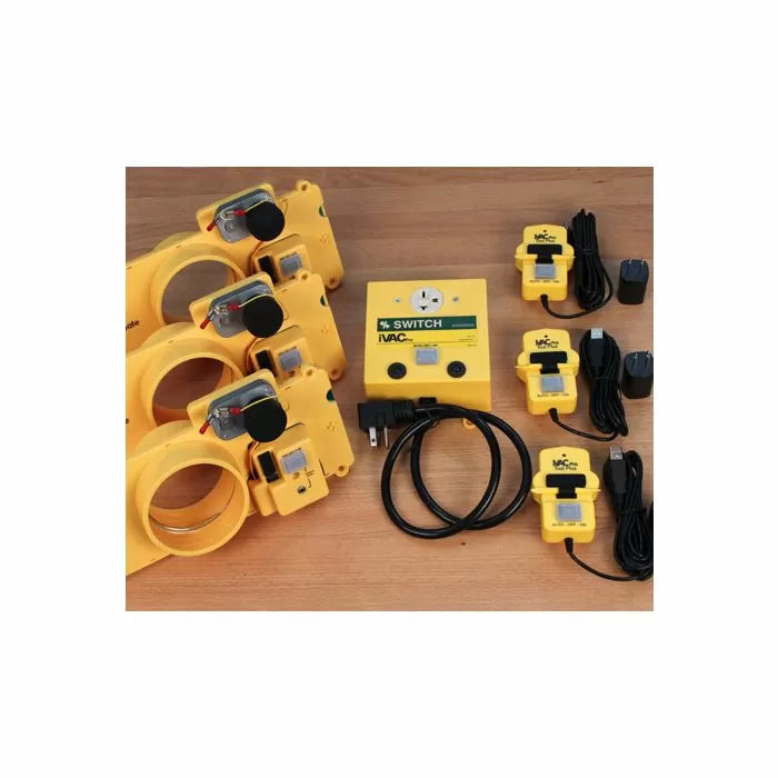 Workshop dust collection system with yellow blast gates, power switch, and remote sensors on wood surface