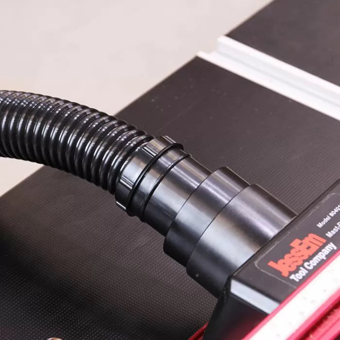 Dust collection hose and adapter attached to woodworking tool table