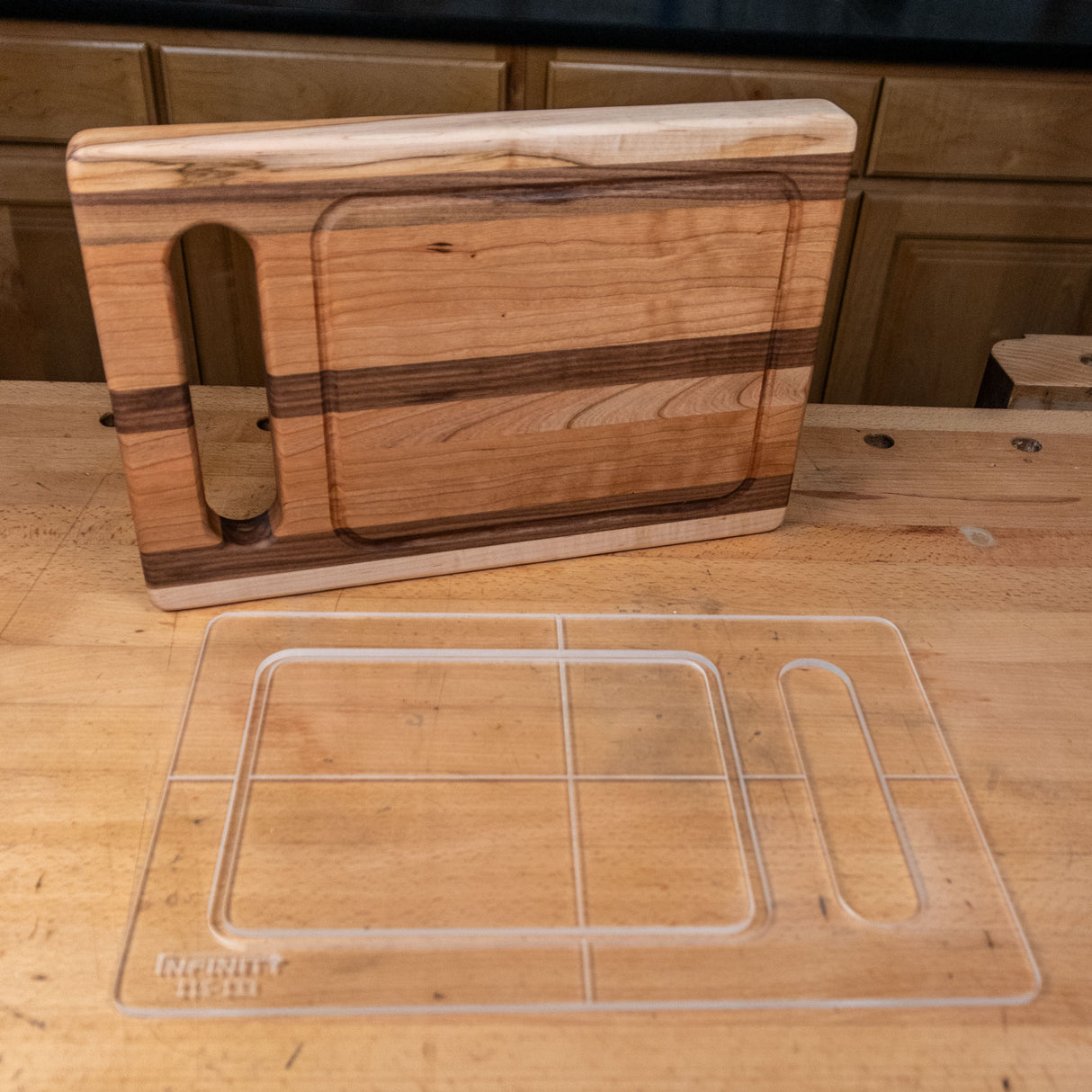 Clear acrylic cutting board template on workbench next to finished wood cutting board