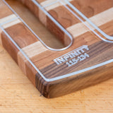 Acrylic cutting board template edge closeup on wood surface with engraved markings.