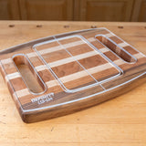 Acrylic cutting board template overlay on a striped wood cutting board with handle slots.