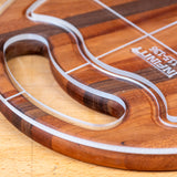 Acrylic cutting board template closeup on wood surface, showing precision cut lines and handle shape