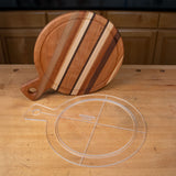 Clear acrylic cutting board template and striped wooden cutting board on a workbench