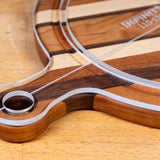 Acrylic cutting board template on striped hardwood cutting board closeup