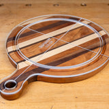 Acrylic cutting board template overlay on round striped wooden cutting board with handle