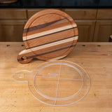 Clear acrylic cutting board template next to a striped wood cutting board on a workbench