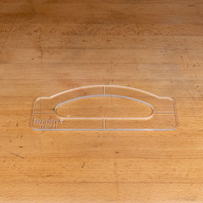 Clear acrylic handle template for woodworking on a wooden workbench