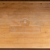 Clear acrylic handle template with engraved guidelines on a woodworking bench