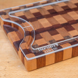 Acrylic cutting board template edge on checkered wood cutting board, close-up view