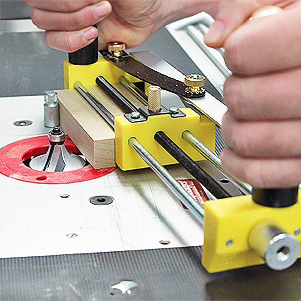 Woodworking router table with push block jig guiding wood for precise cutting