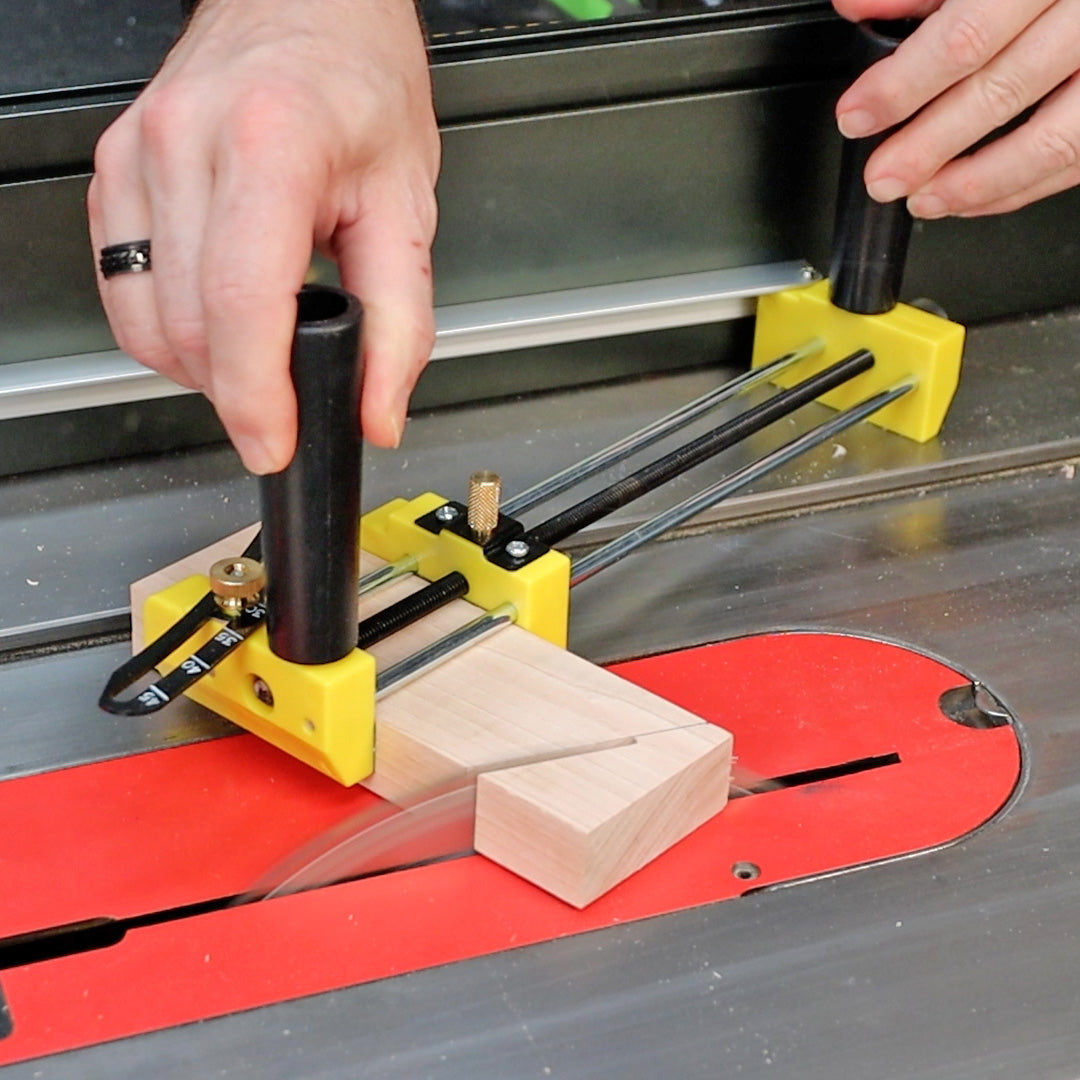 Table saw jig with yellow push blocks guiding wood for precise angled cutting