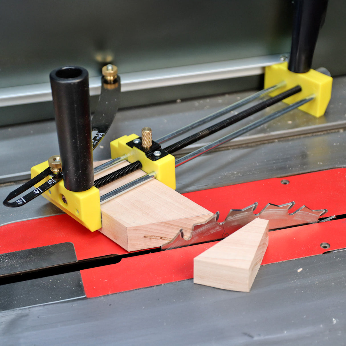 Table saw with yellow miter gauge cutting angled wood piece for woodworking precision