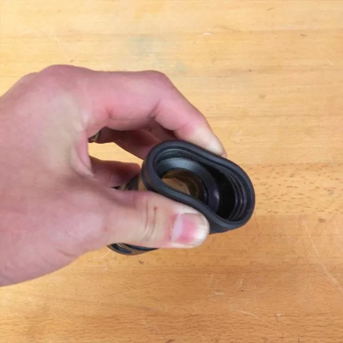 Hand holding woodworking dust collection fitting on a workbench