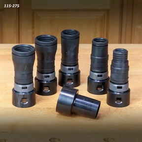 Set of six black plastic woodworking dust collection fittings on a wooden workbench