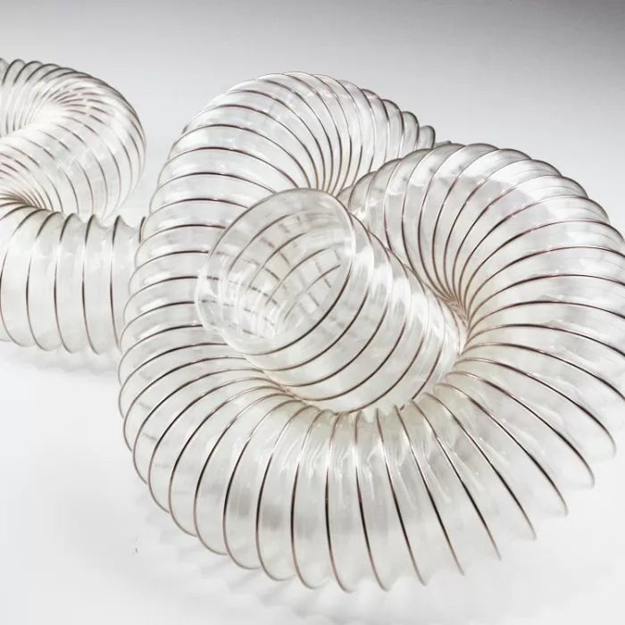 Clear flexible dust collection hose for woodworking, coiled on white background