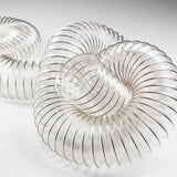 Clear flexible dust collection hose for woodworking, coiled on white background