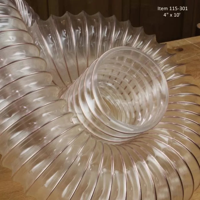 Clear flexible dust collection hose coiled on a woodworking bench, 4 inch diameter, 10 foot length