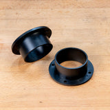 Two black 2-1/2 inch dust collection connectors on a wooden workbench