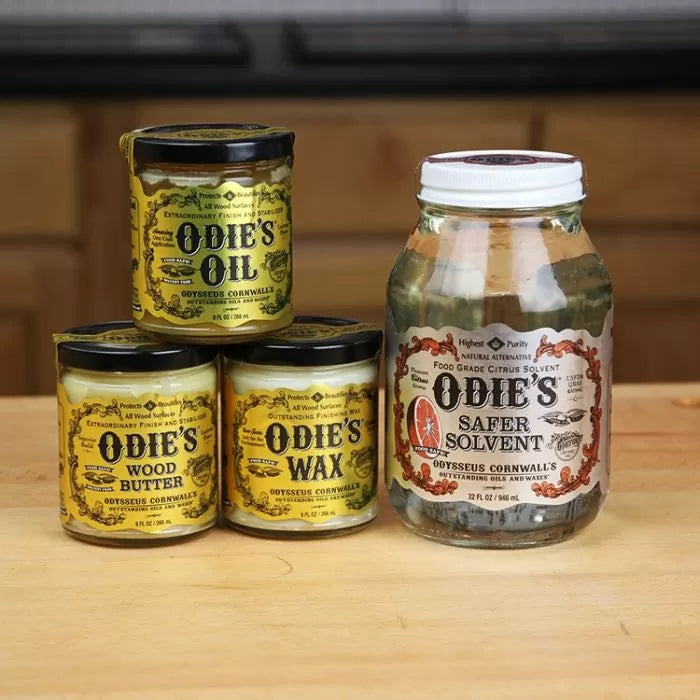 Odie's Oil, Wood Butter, Wax, and Safer Solvent jars for woodworking finishes on a wood table