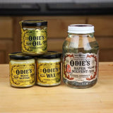 Odie's Oil, Wood Butter, Wax, and Safer Solvent jars for woodworking finishes on a wood table