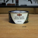 Liberon Wax Polish Black Bison Neutral tin on a wooden workbench in a workshop setting
