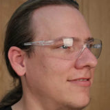 Person wearing clear safety glasses, wood background, protective eyewear for woodworking