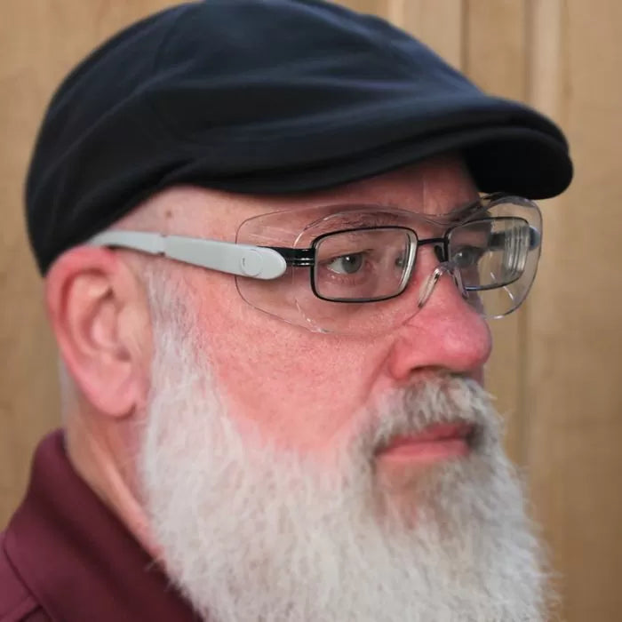 Man wearing clear safety glasses over prescription glasses for woodworking protection