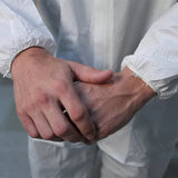 Close-up of hands in white protective coveralls for woodworking safety