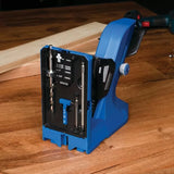 Blue pocket hole jig with integrated drill bit storage on a wood workbench