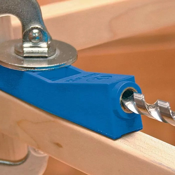 Blue pocket hole jig with clamp and drill bit on a woodworking project