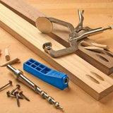 Pocket hole jig kit with clamp, drill bit, screws, and wood on a woodworking bench.