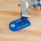 Pocket hole clamp securing blue jig on wooden workbench for woodworking projects
