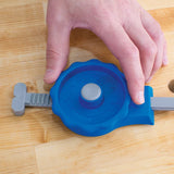 Woodworker using a blue and gray router table accessory on a wooden workbench