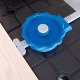 Blue adjustable woodworking clamp securing wood on a black workbench
