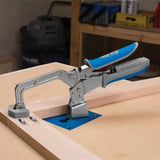 Woodworking toggle clamp with blue handle securing wood piece to workbench