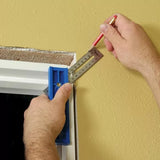 Hand using marking gauge and pencil to measure and mark around door frame on yellow wall