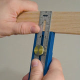 Woodworking marking gauge tool measuring wood edge for precise layout