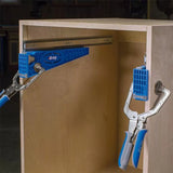 Drawer slide jig clamps attached to a wooden cabinet for precise installation