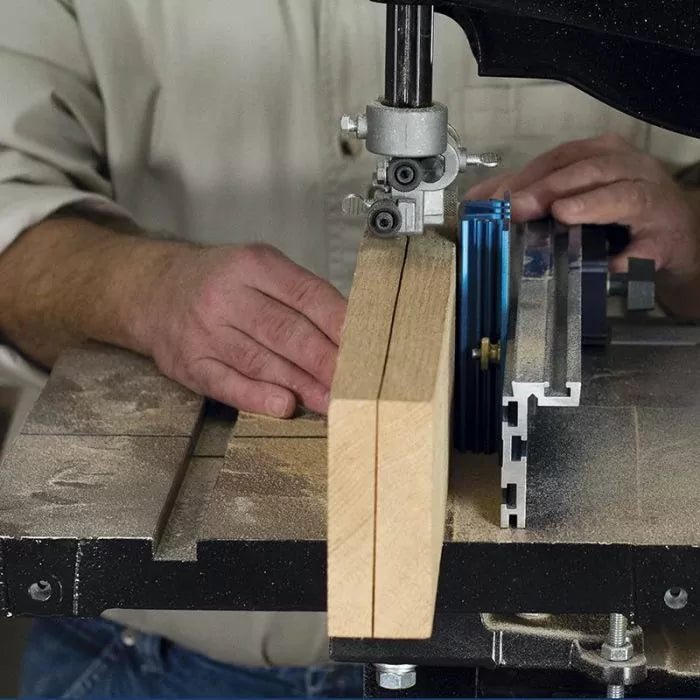 Man using band saw to cut wood with precision fence in woodworking shop